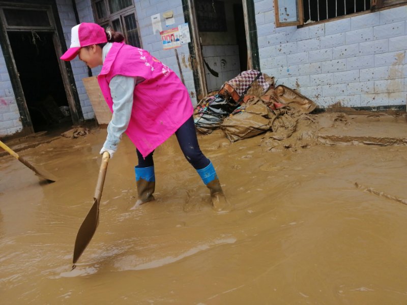 大堡镇巾帼志愿者为受灾群众清理房屋淤泥.jpg
